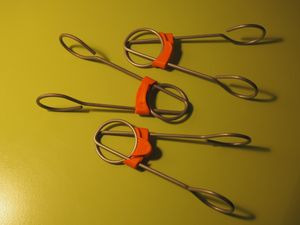3 wire formed parts with orange clips on them.
